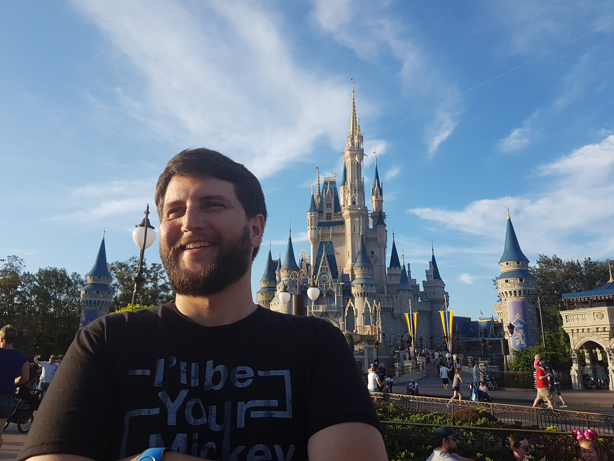 Rudi sorrindo com o Castelo da Cinderela ao fundo no fim da tarde