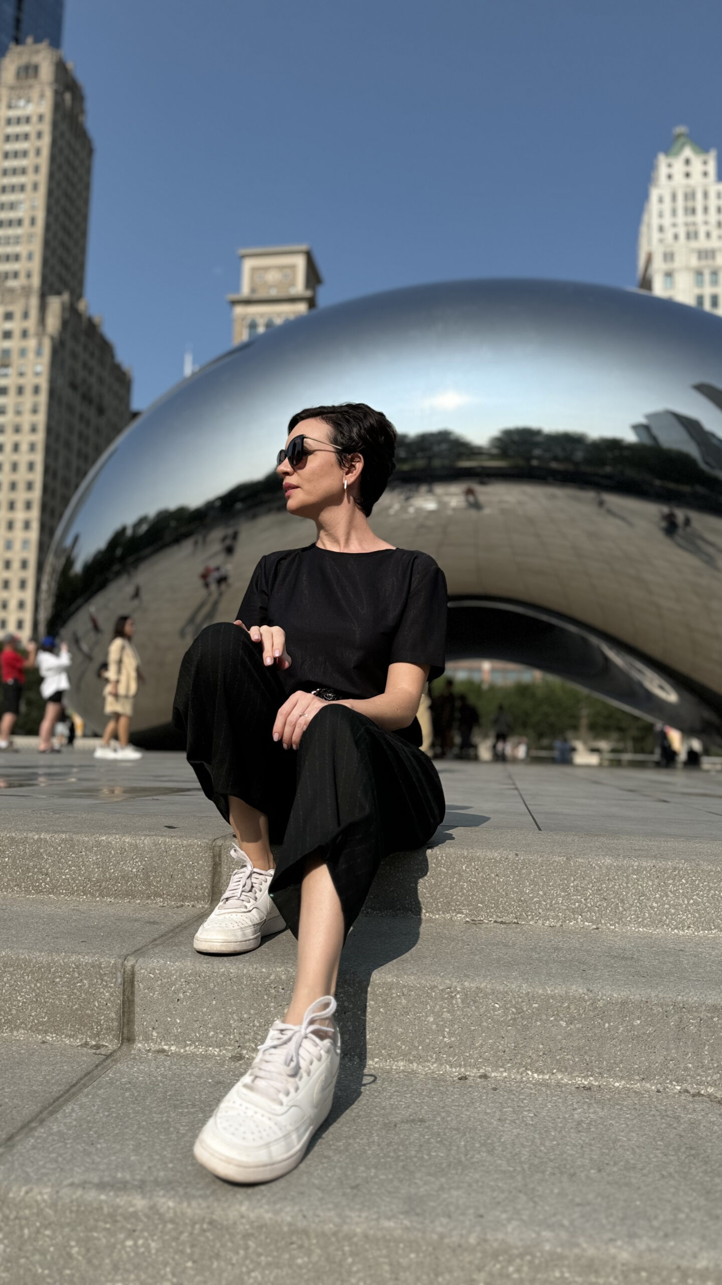 Carol sentada em frente à escultura Cloud Gate, o Bean, no Millennium Park em Chicago