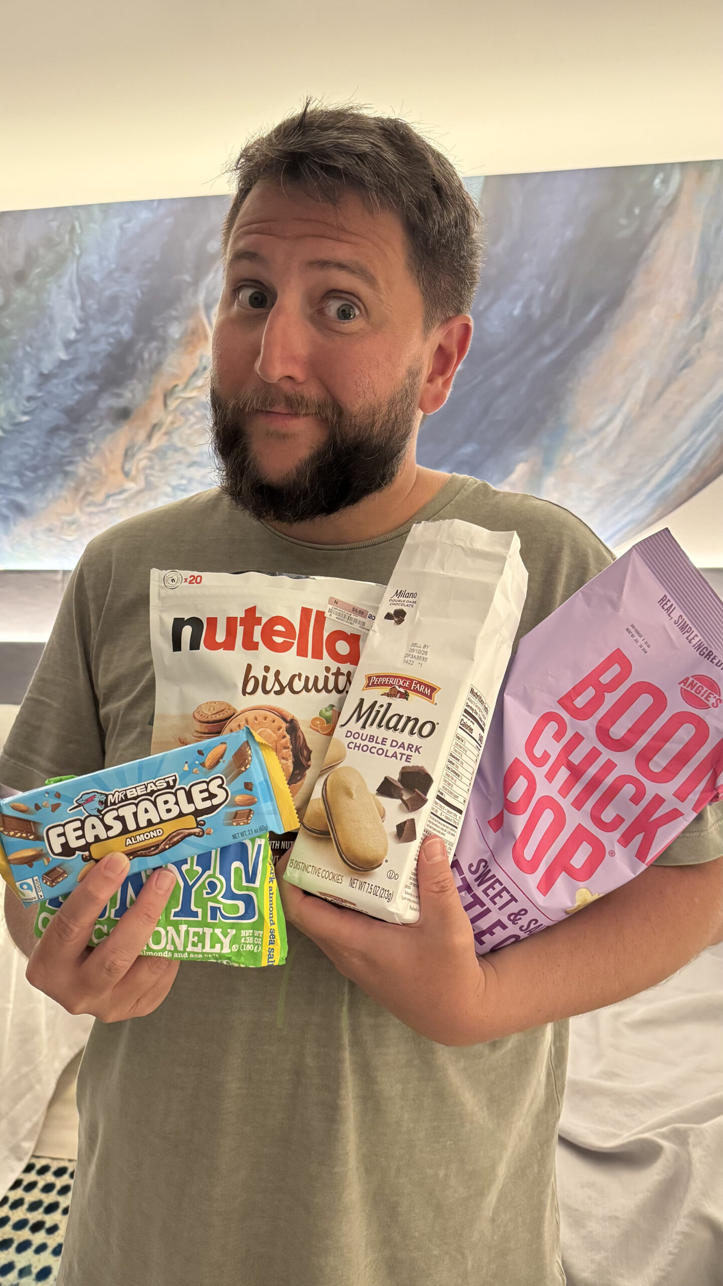 Rudi segurando snacks americanos Nutella Biscuits Milano Boom Chicka Pop em Orlando