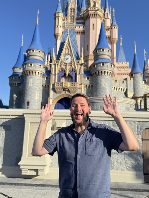 Rudi em frente ao castelo da Cinderela no Magic Kingdom de madrugada com poucas pessoas ao redor