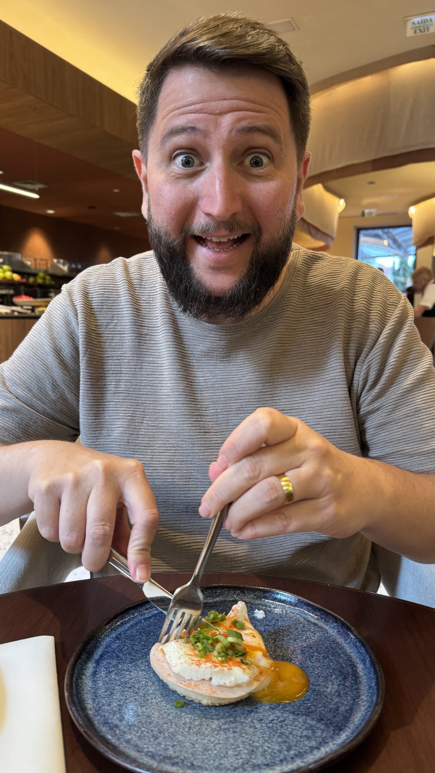 Rudi saboreando o prato Macáya com ovo e molho sobre pasta de feijão no restaurante Macáya do Pullman Ibirapuera