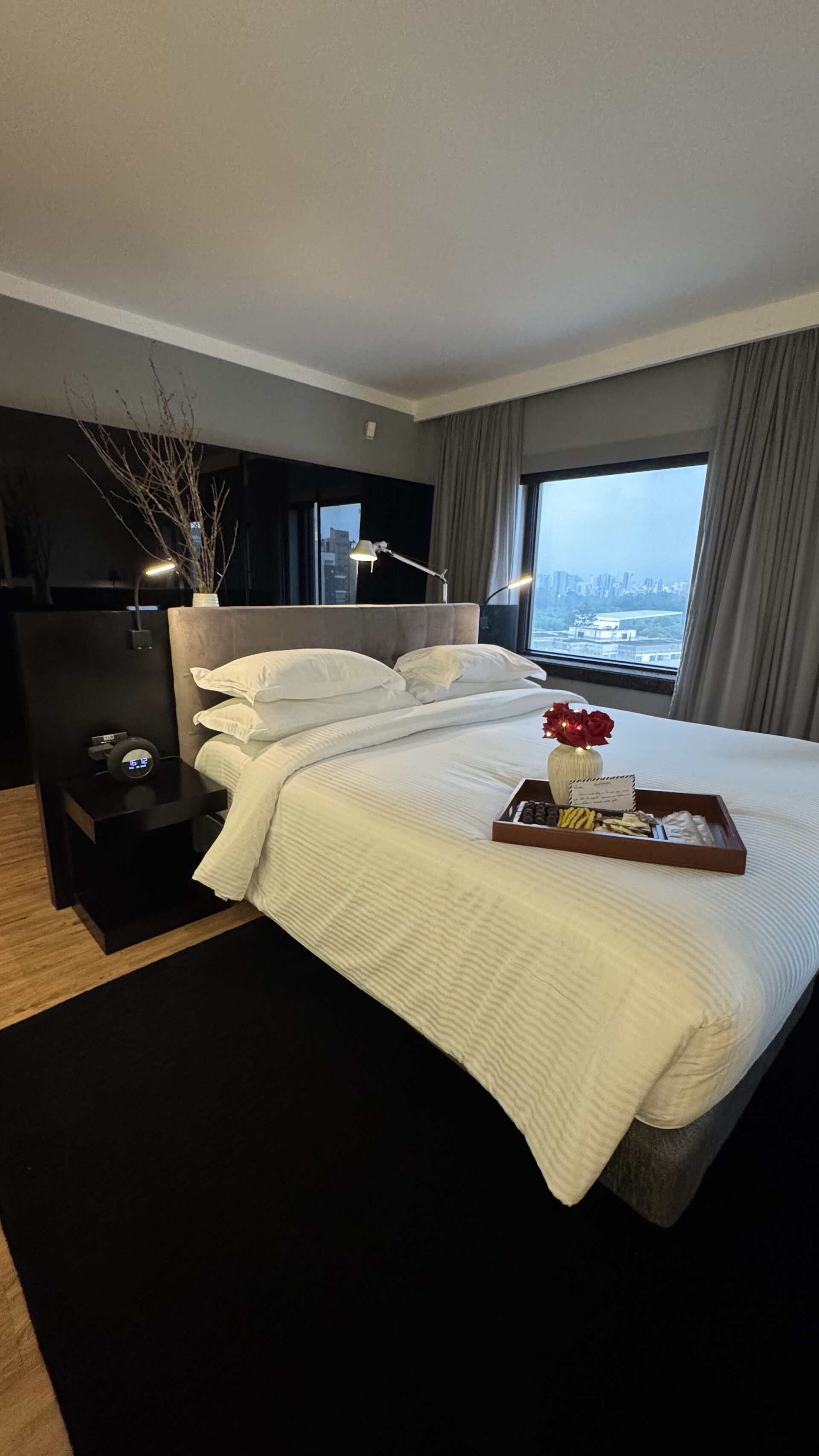 Cama king size da suíte executiva Trousseau no Pullman Ibirapuera com bandeja de chocolates Dengo e rosas da experiência romântica ALL Accor