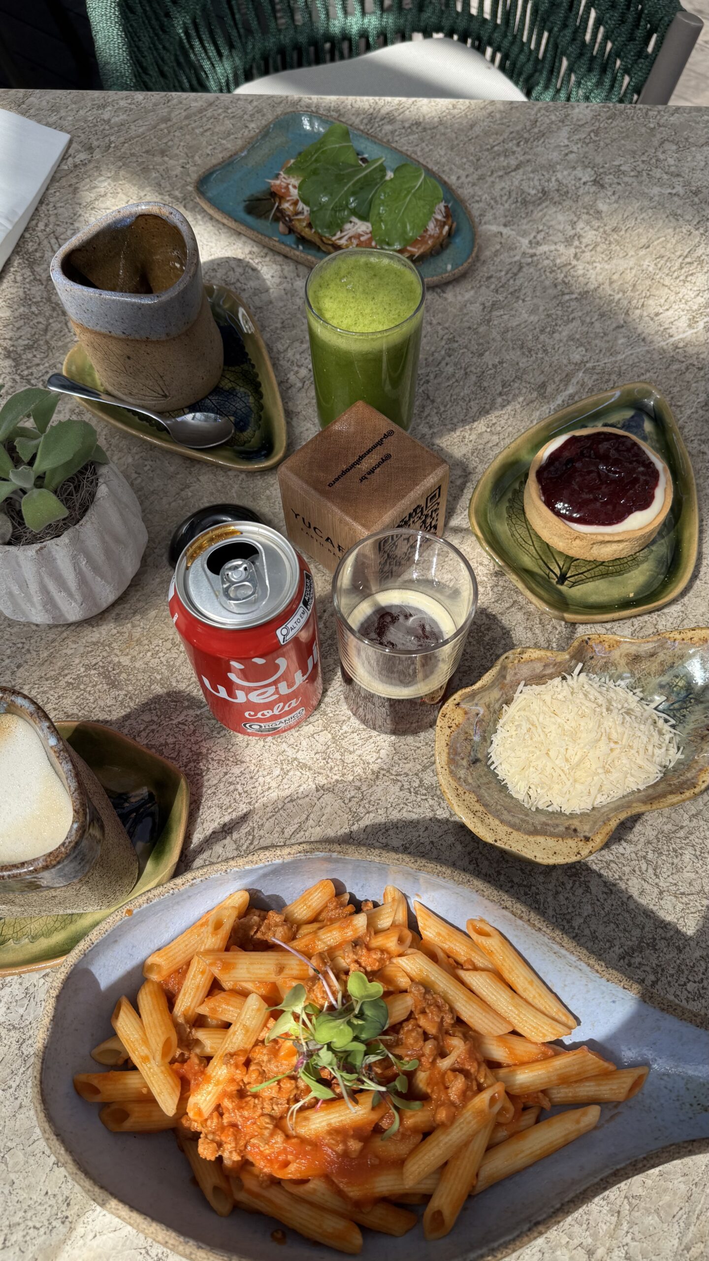 Mesa completa do almoço no YUCAFÉ no Pullman Ibirapuera com penne bolognese, suco verde, tartelete de limão e Coca orgânica