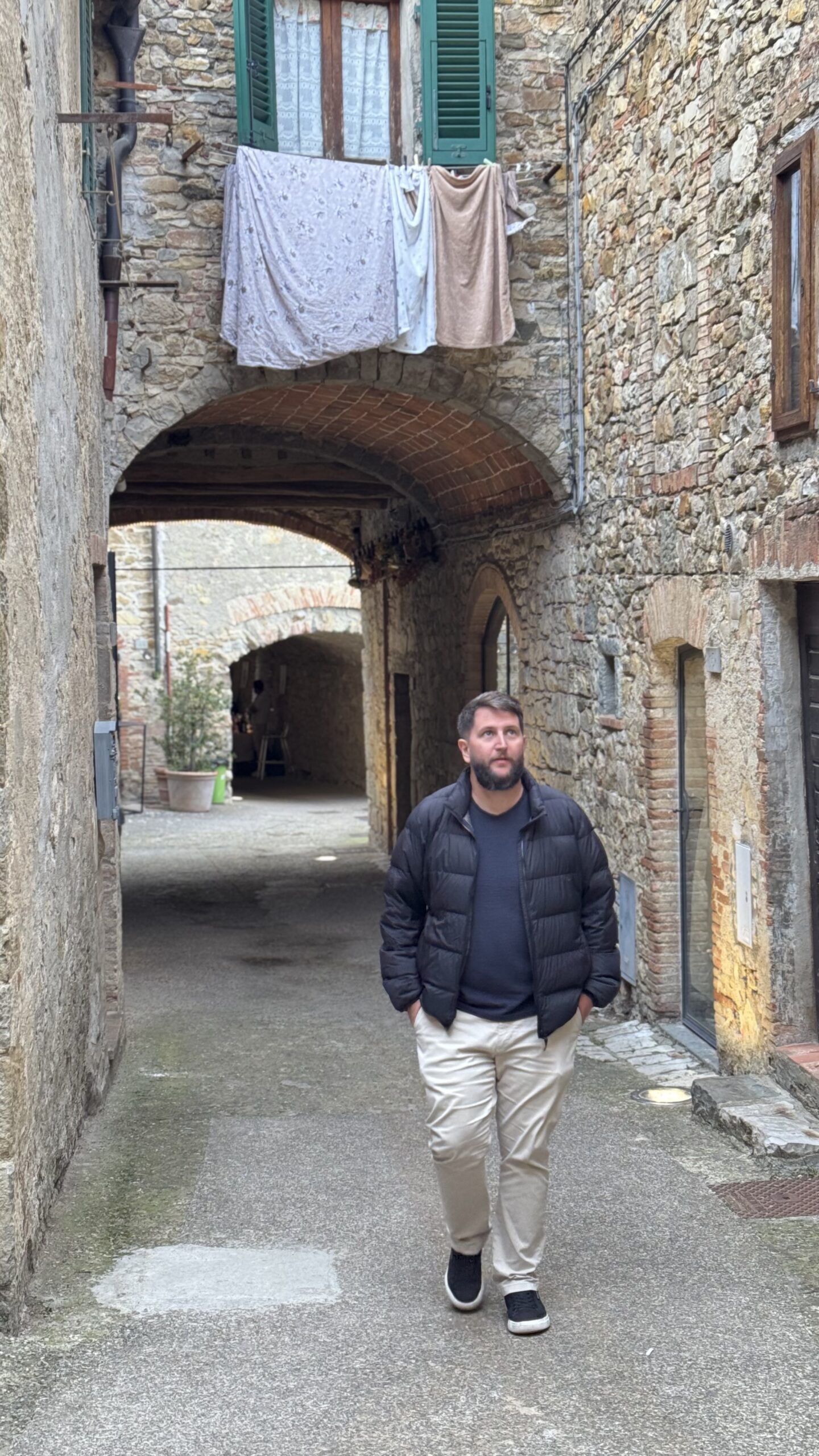 Rudi andando num beco de pedra medieval em Castellina in Chianti