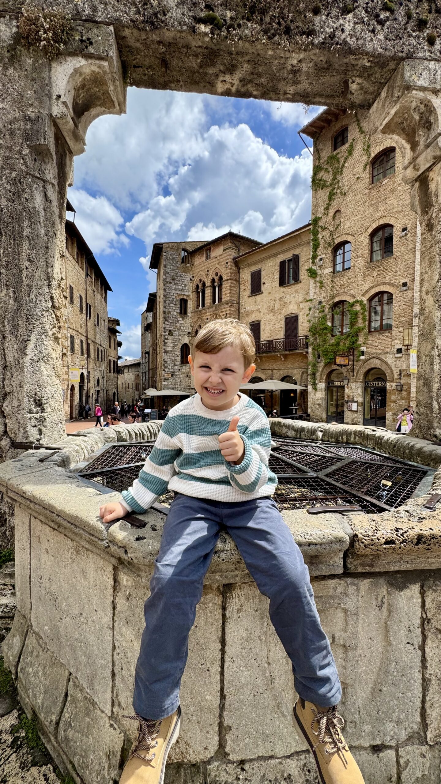 Sam sentado na cisterna medieval da Piazza della Cisterna em San Gimignano