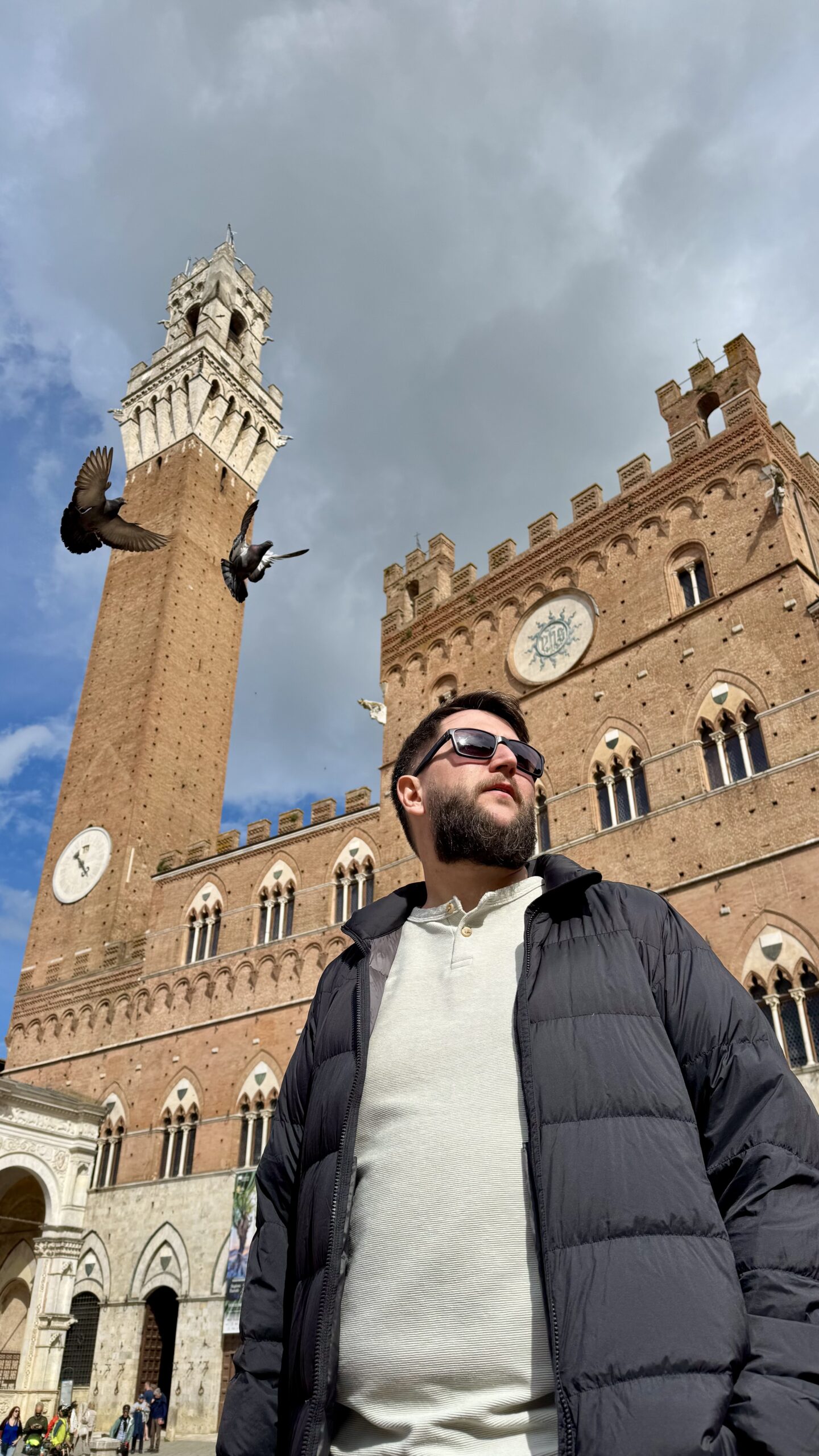 Rudi na Piazza del Campo de Siena com a Torre del Mangia ao fundo