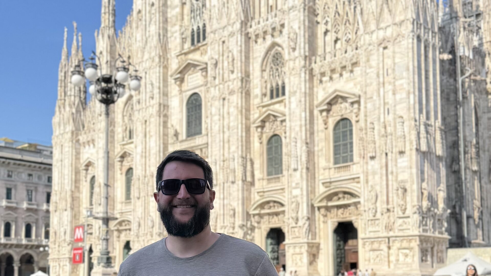 Homem em frente ao Duomo de Milão, na Praça do Duomo