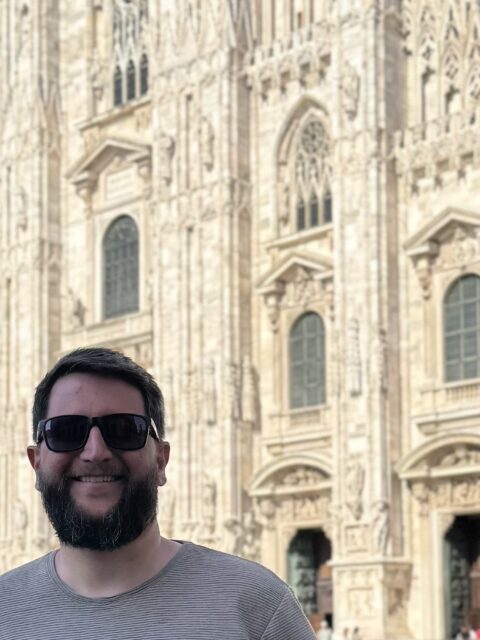 Homem em frente ao Duomo de Milão, na Praça do Duomo