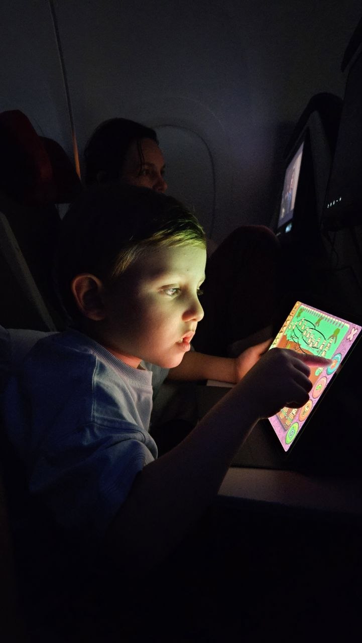 Samuel usando tablet durante o voo noturno