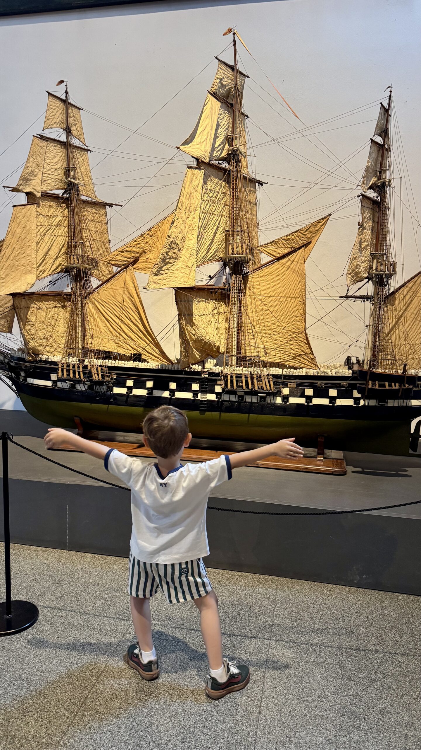 Criança observando um modelo de embarcação à vela no Museu Leonardo da Vinci