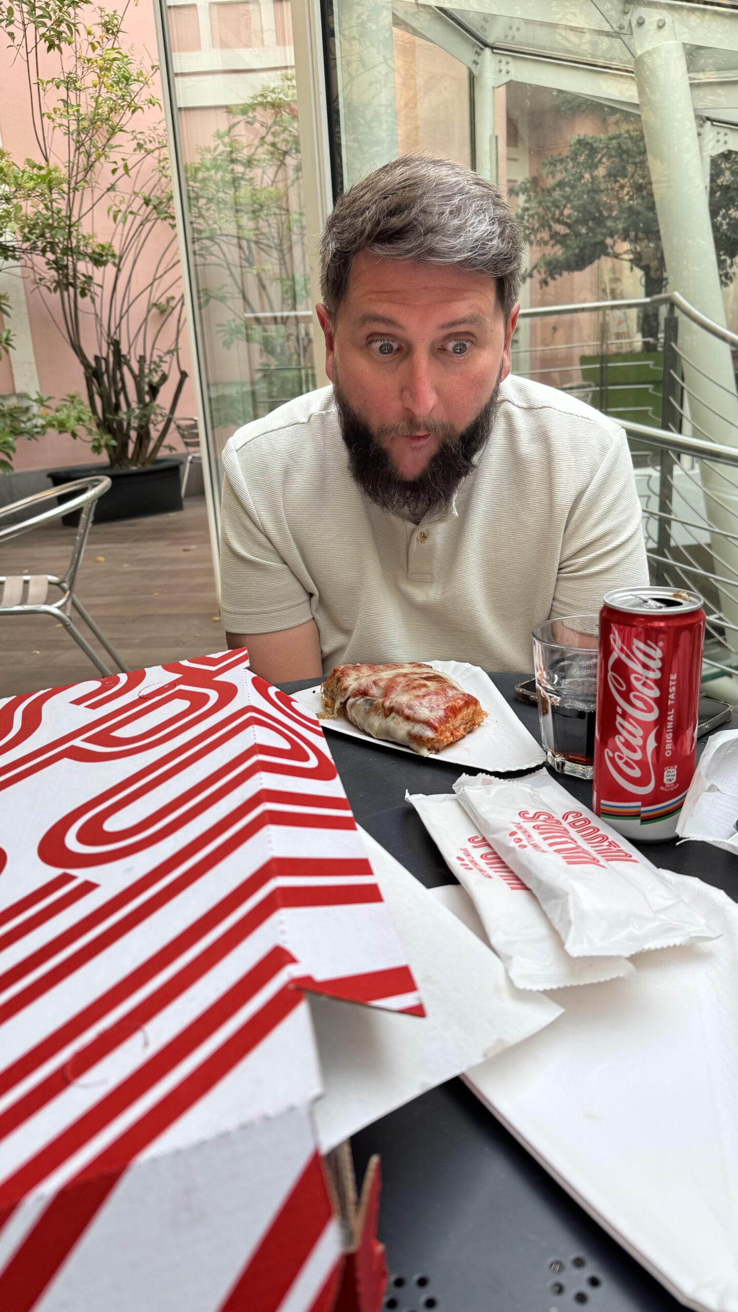 Homem com fatia de pizza da Spontini Milano