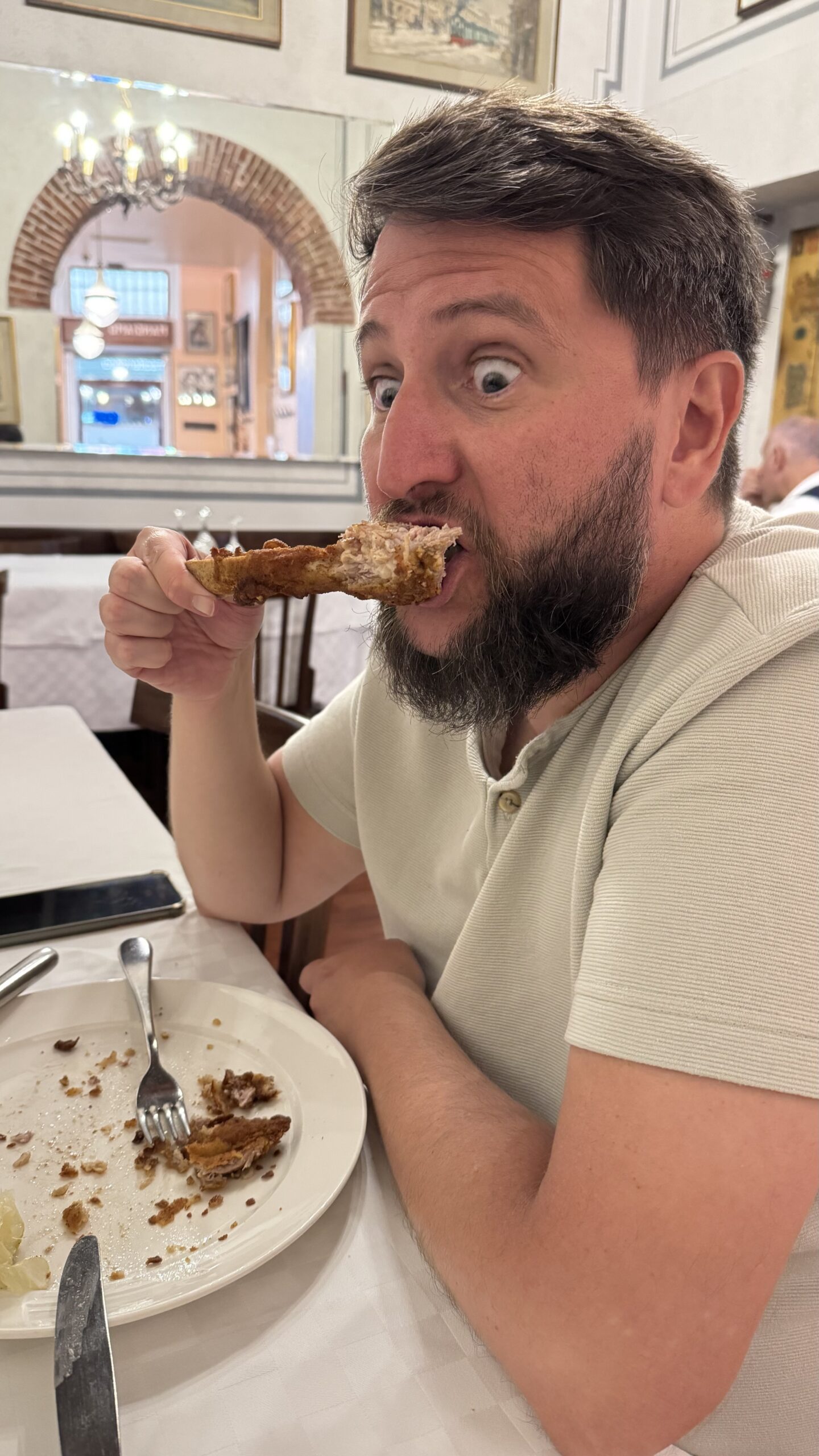 Homem comendo cotoletta alla milanese na Trattoria Milanese em Milão