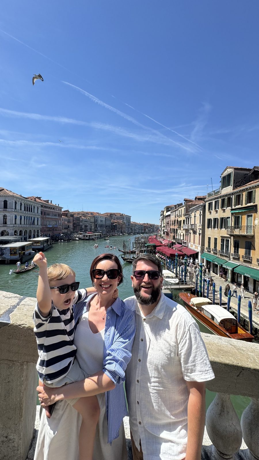 Família posando na Ponte de Rialto com vista do Canal Grande ao fundo