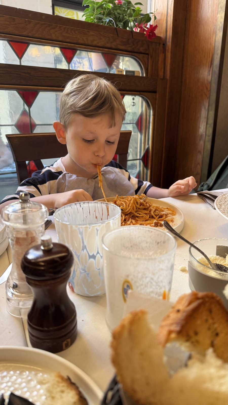 Samuel comendo macarrão ao molho de tomate em restaurante de Veneza