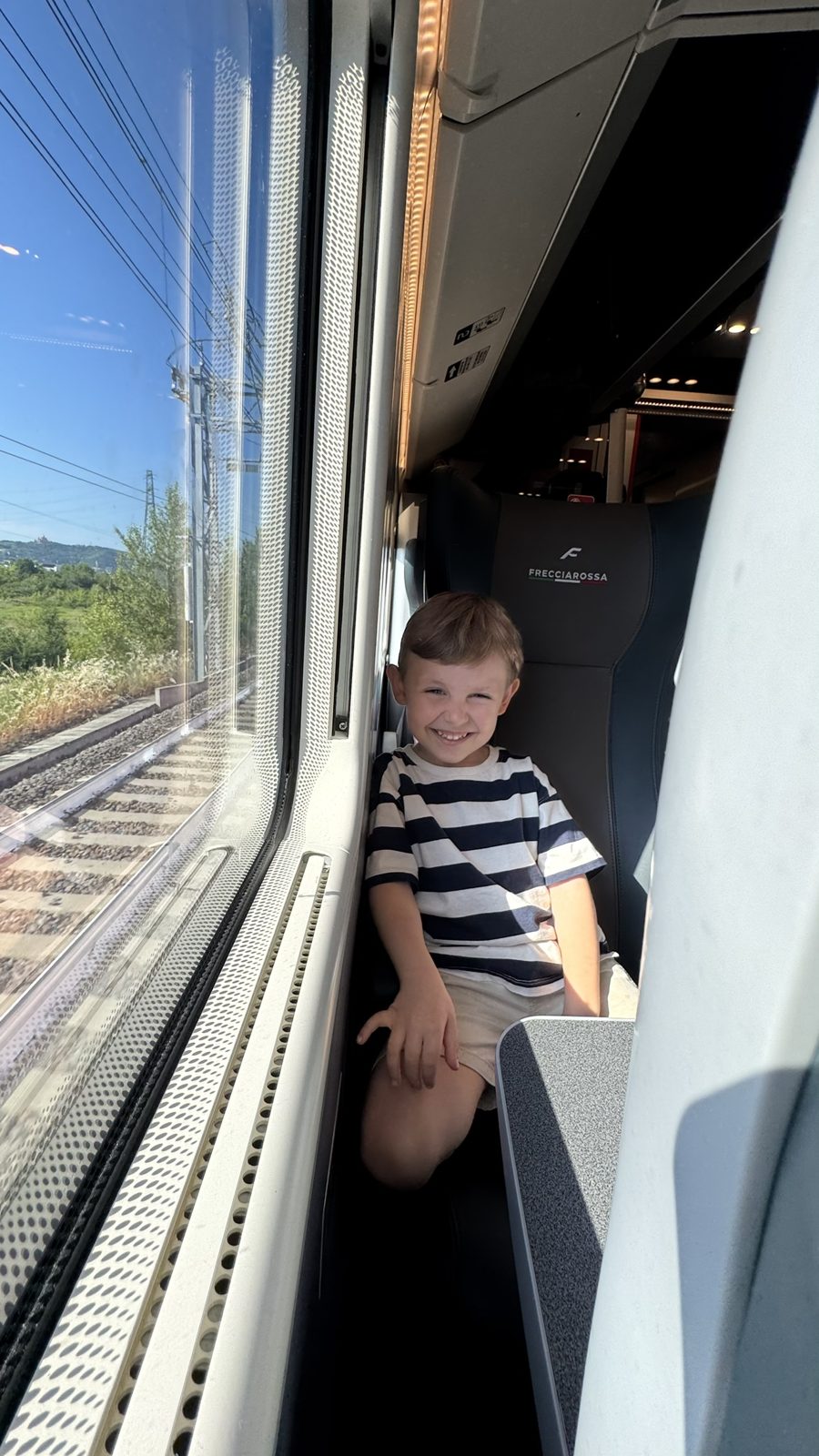 Samuel sorrindo dentro do trem Frecciarossa durante o trajeto até Veneza