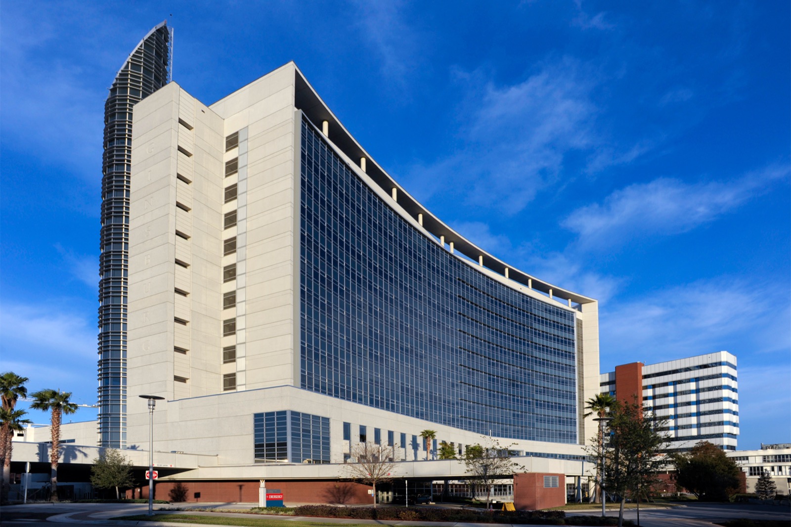 Predio principal do hospital AdventHealth Orlando visto da rua em dia de ceu azul