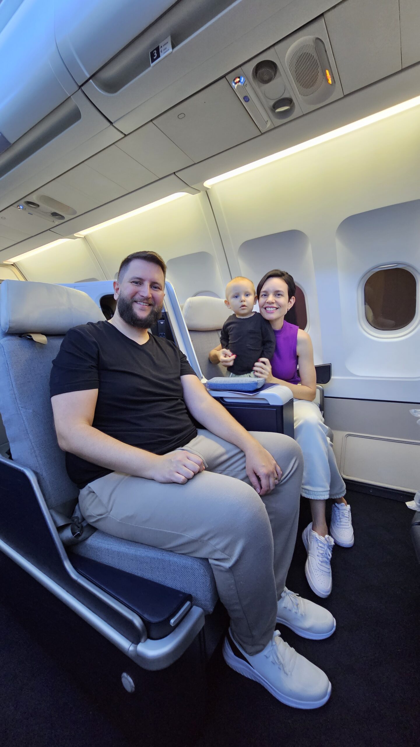 Família reunida na cabine executiva da Air France com o Samuel bebê no colo entre as poltronas