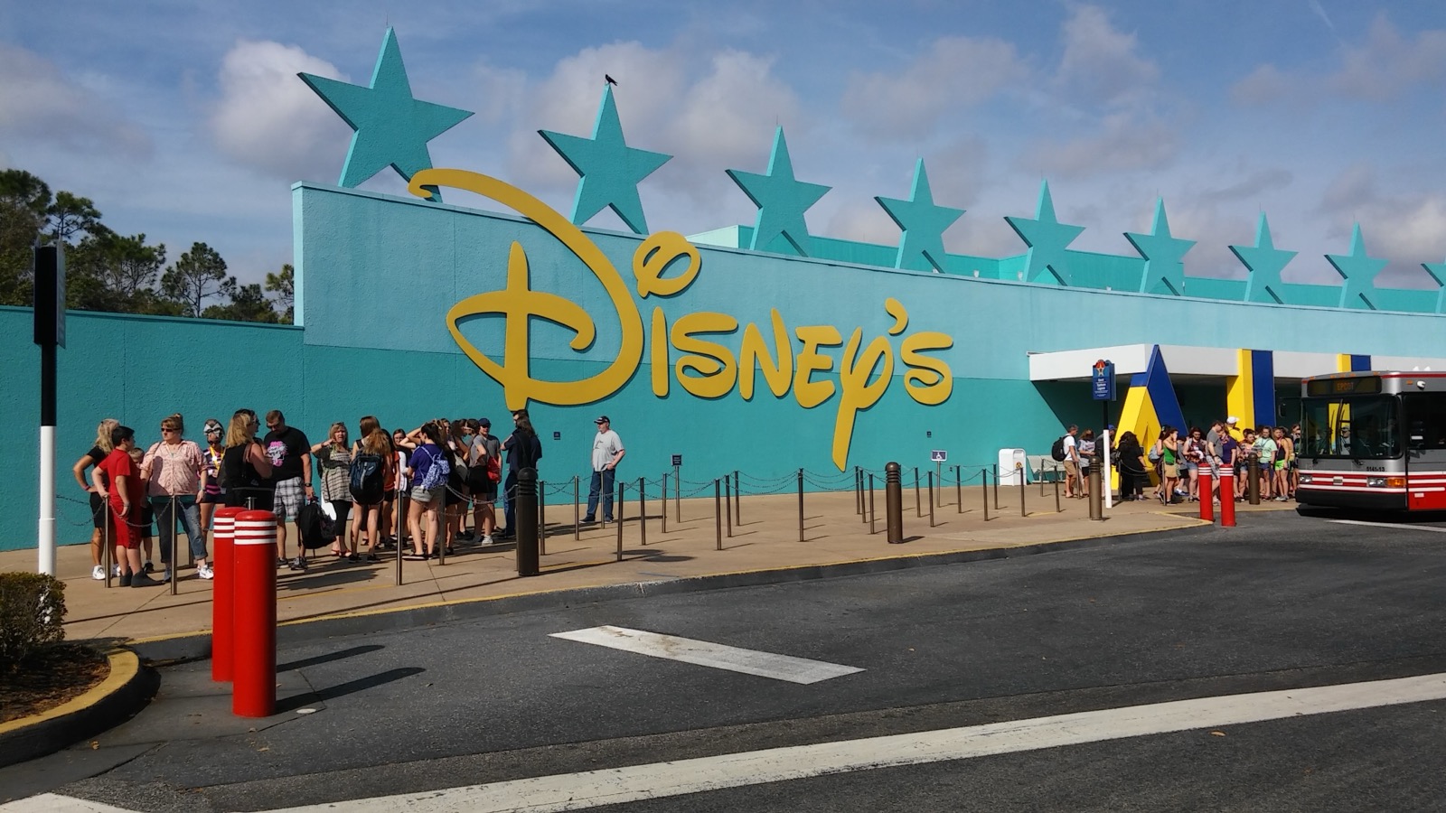 Entrada do Disney All-Star Music Resort com parede azul de estrelas e onibus ao fundo