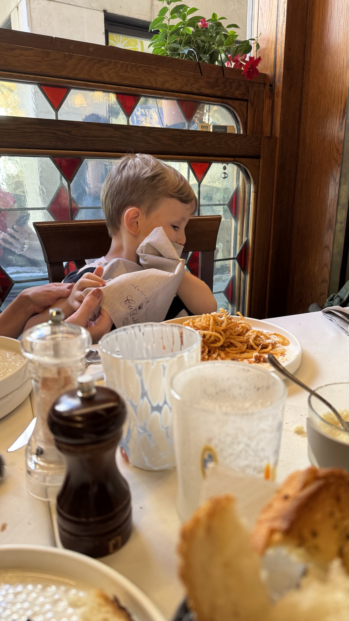 Criança comendo espaguete à mesa em um restaurante de Veneza
