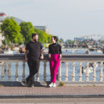 Casal com o bebe no colo em uma ponte cercada de bicicletas com um canal de Amsterda ao fundo, em ensaio fotografico profissional