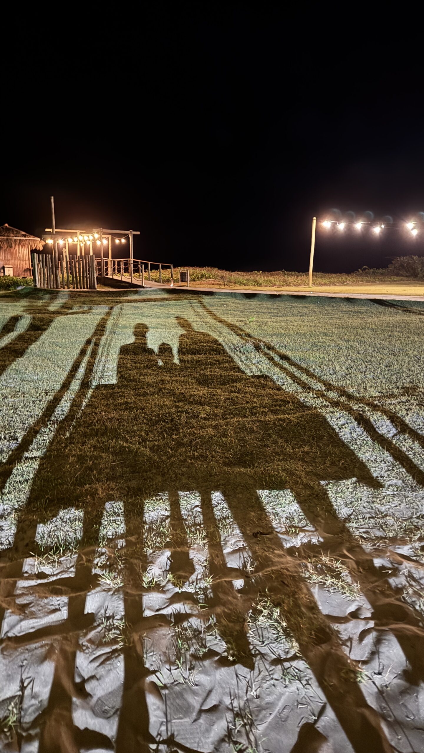 Caminho iluminado à noite entre os bangalôs do Angá Hotel