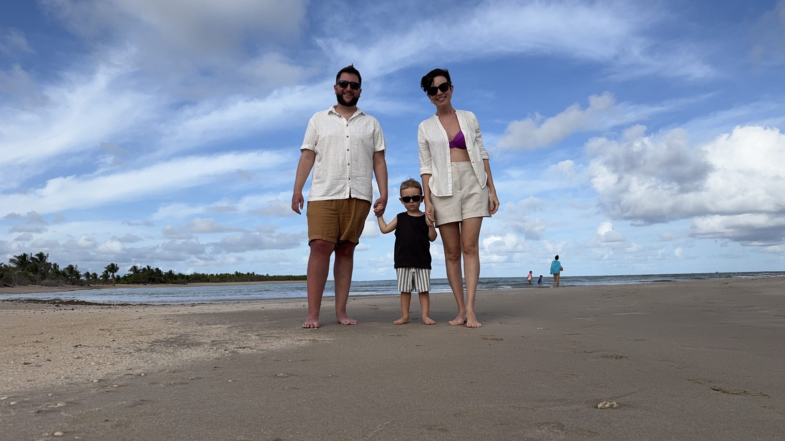 Família na Praia Porto da Rua em frente ao Angá Hotel, com o mar calmo ao fundo