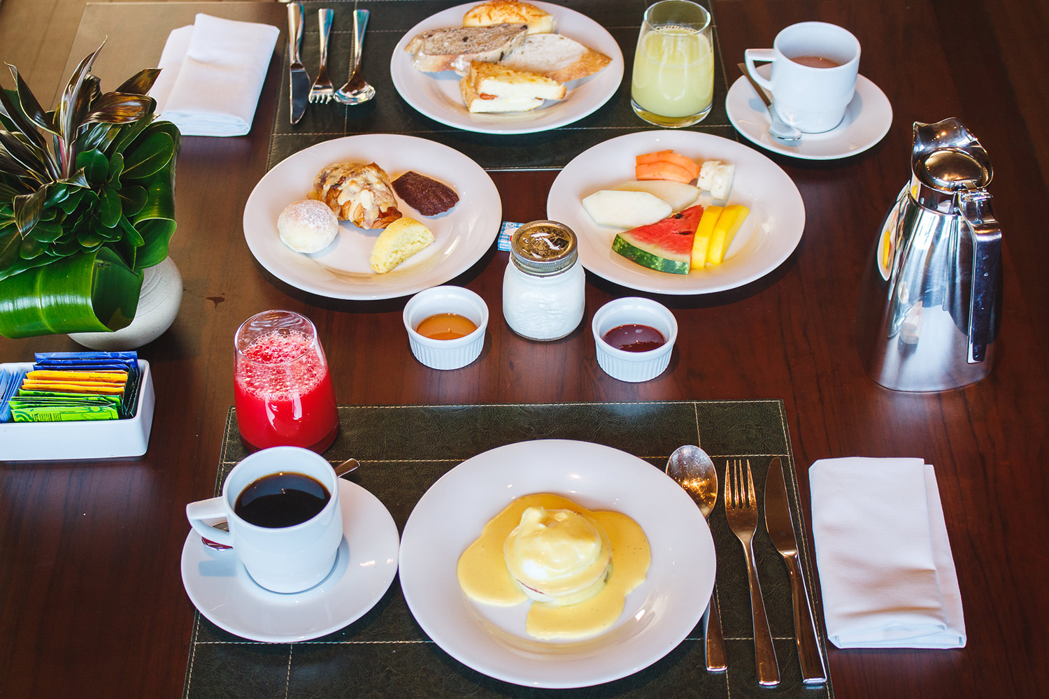 Mesa do café da manhã do B Hotel Brasília com ovos beneditinos, sucos naturais e pães