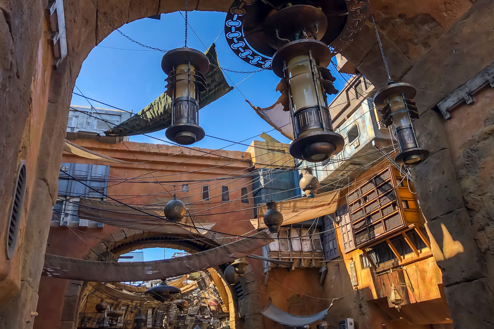 Beco de Black Spire Outpost em Galaxy's Edge, com arcos de pedra e construções terracota