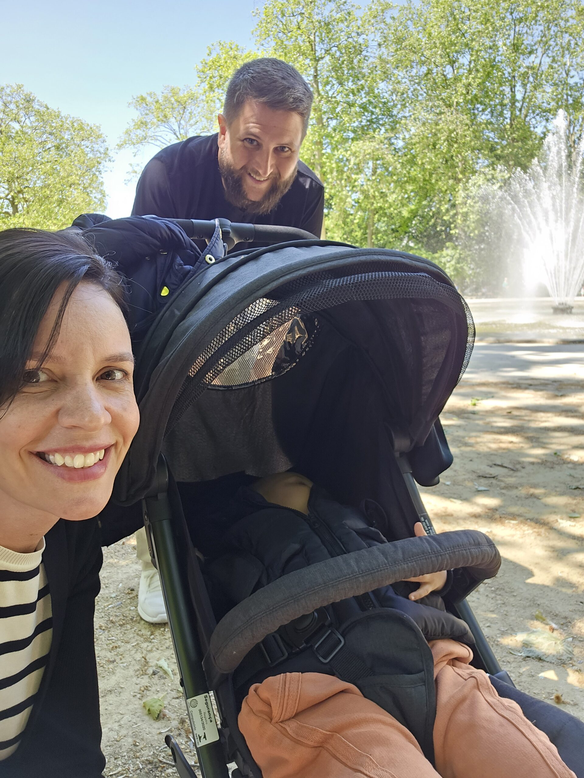 Rudi caminhando com mochila pelo centro historico de Bruxelas com jardins e predios ao fundo