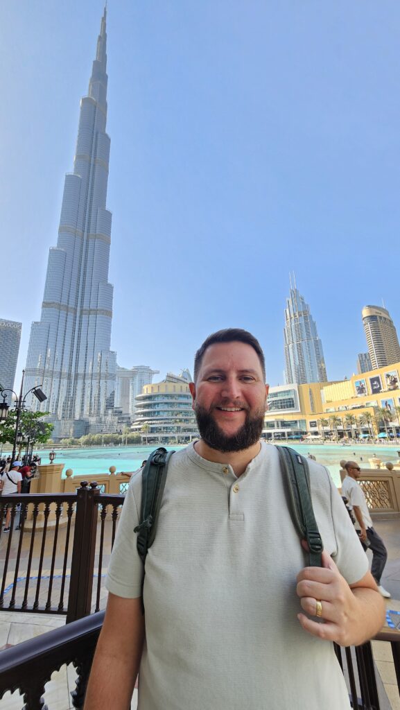 Rudi em frente ao Burj Khalifa e à fonte de Dubai, com o prédio mais alto do mundo ao fundo