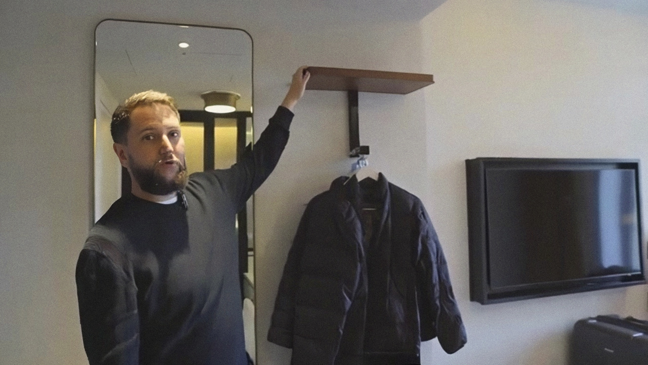 Cena do nosso video mostrando o cabideiro pequeno ao lado da TV grande no quarto do Hyde London City