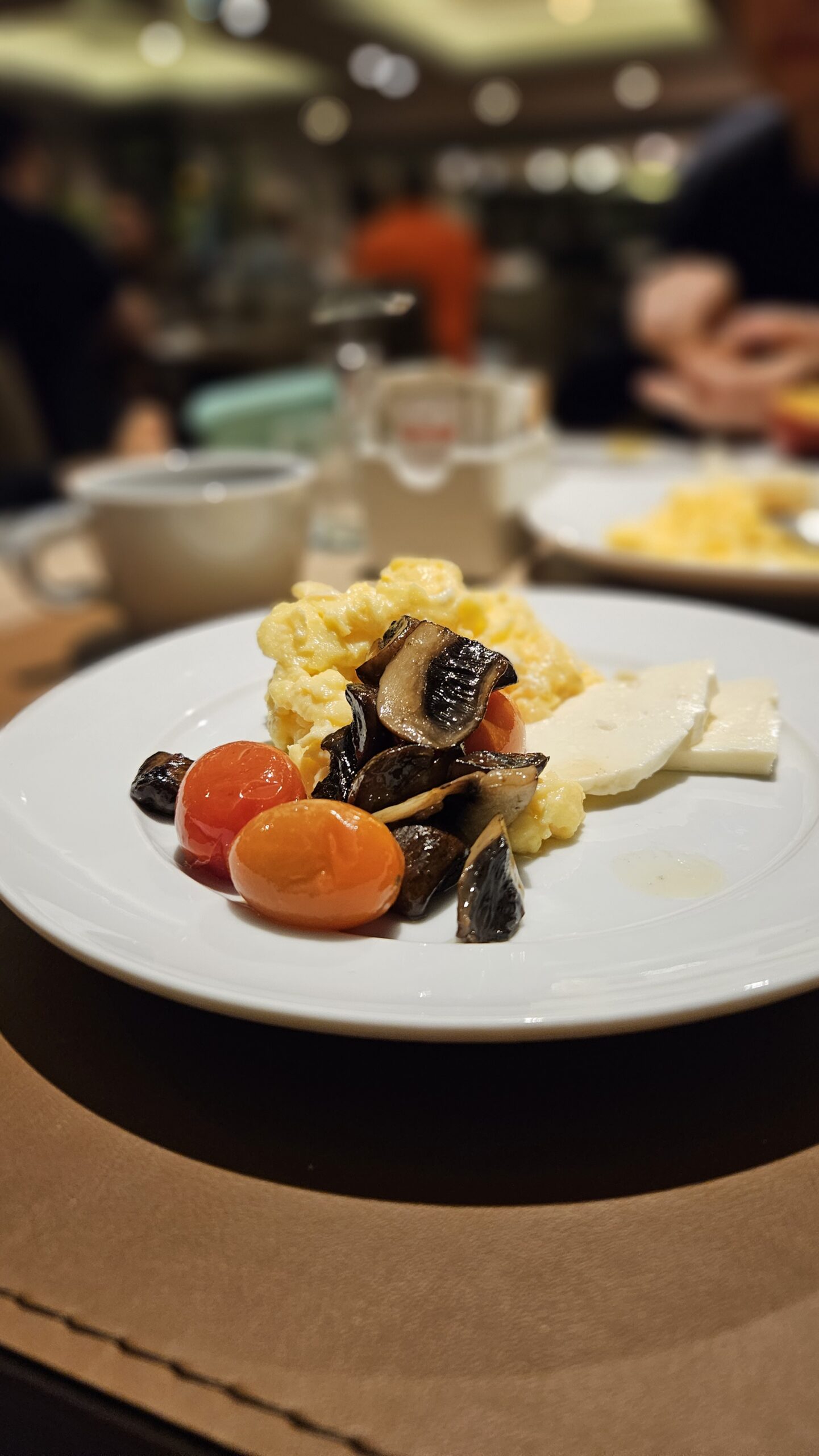 Prato do cafe da manha do Grand Mercure Curitiba com ovos mexidos, cogumelos salteados, tomate cereja e queijo brie