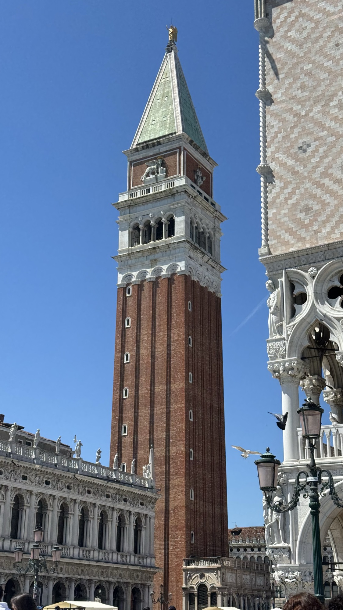 Campanile de San Marco, a torre de tijolos com o topo piramidal, visto de baixo