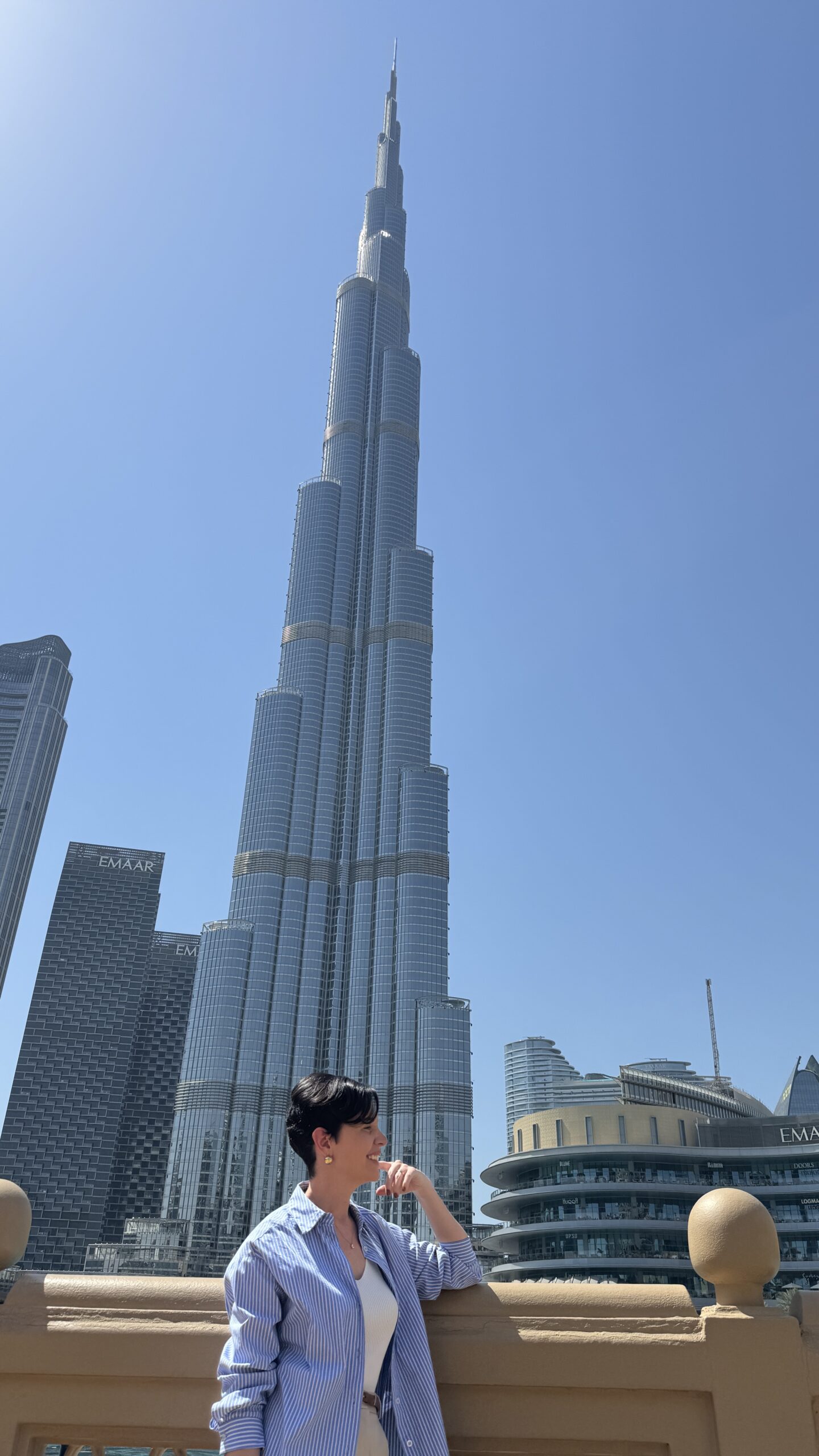 Carol olhando para cima em frente ao Burj Khalifa em Dubai