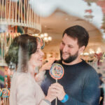 Casal em frente à vitrine da doceria Main Street Confectionery no Magic Kingdom durante viagem aos EUA