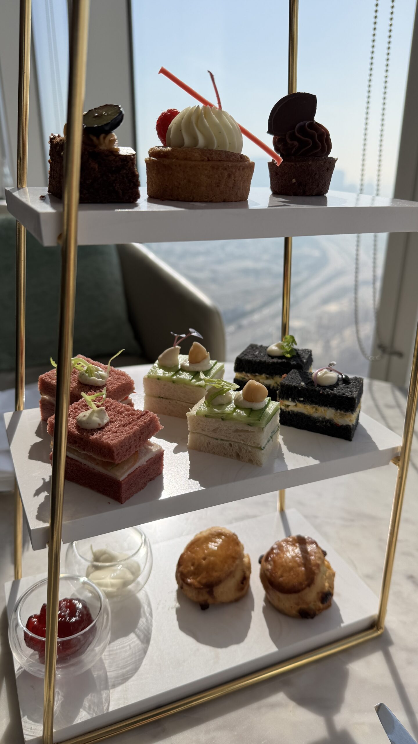 Mesa de chá da tarde com sanduíches, scones e doces no Club Millesime do Sofitel Dubai