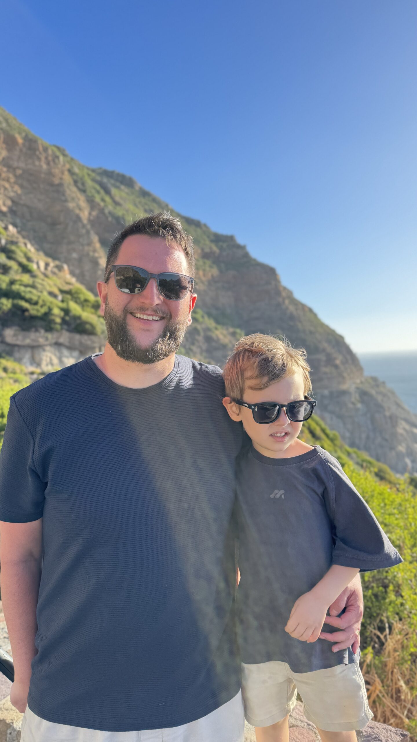 Rudi e Samuel na Chapman's Peak Drive, com as falésias e o oceano ao fundo