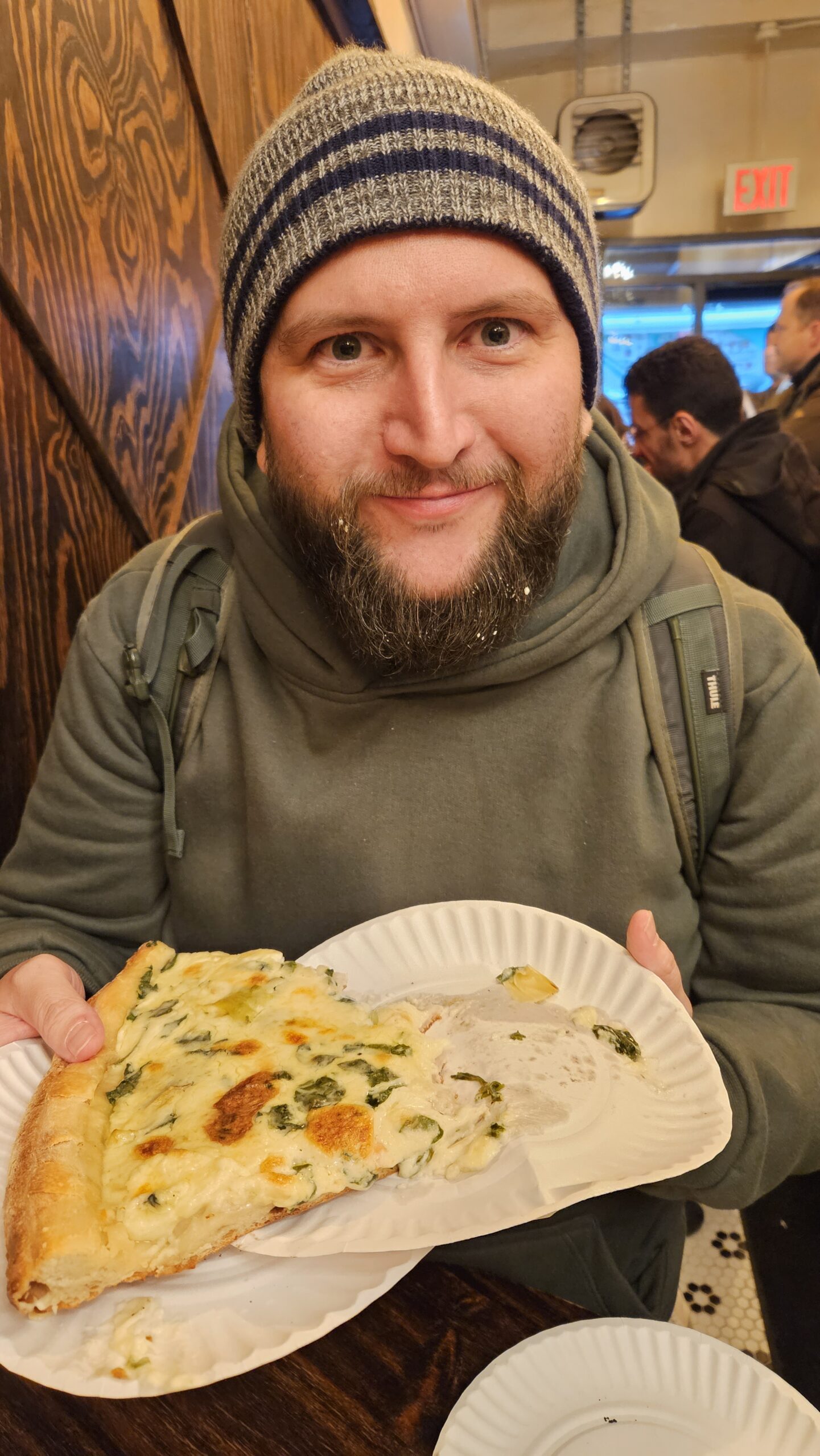 Rudi com fatia de pizza de alcachofra em Nova York