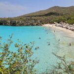Vista aérea de uma praia de Curaçao com penhascos e água turquesa transparente