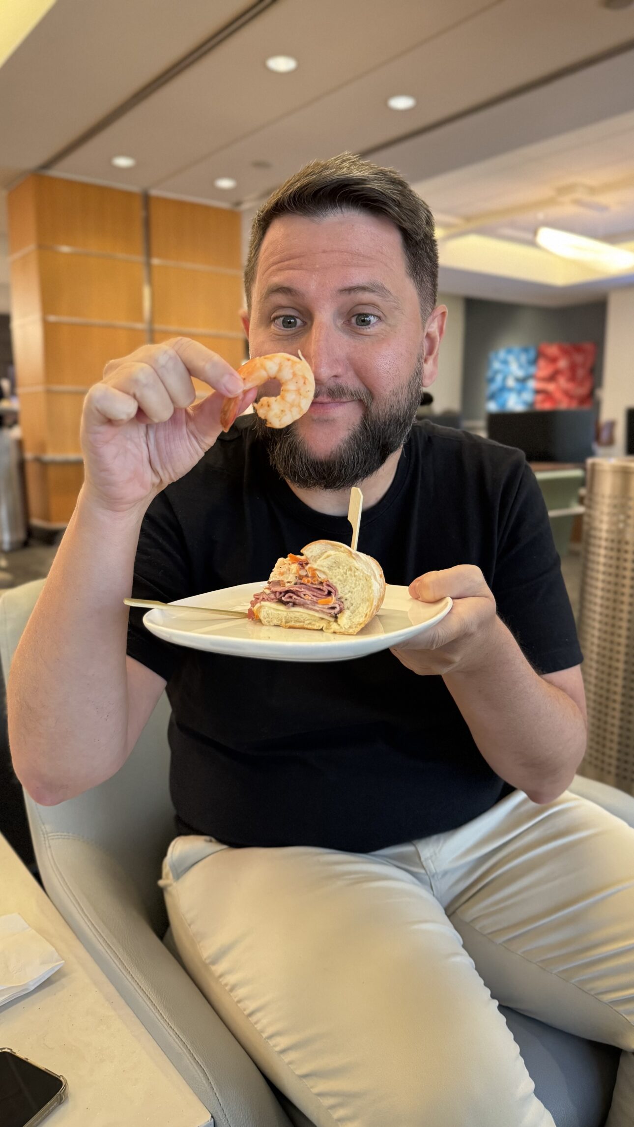Rudi comendo camarão e sanduíche no Delta Sky Club de Atlanta