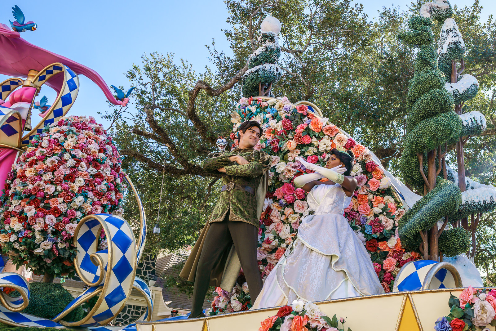 Personagens do filme A Princesa e o Sapo em carro alegórico coberto de flores no desfile do Magic Kingdom