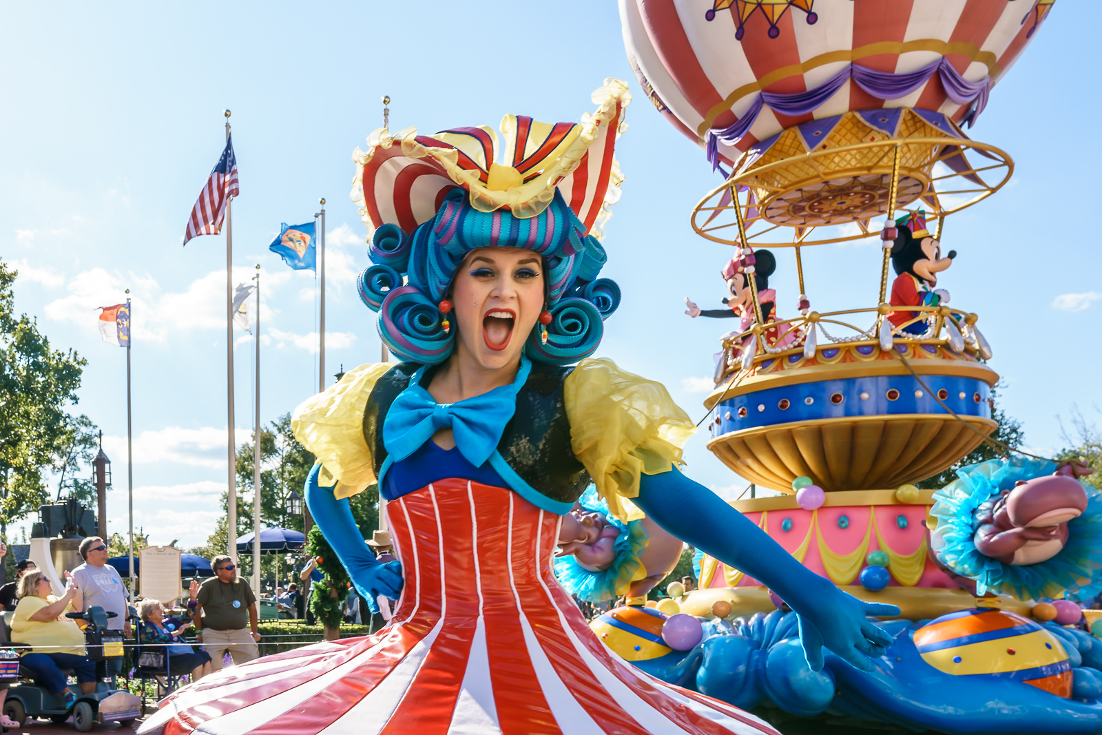 Personagem fantasiada de circo em carro alegórico colorido durante desfile no Magic Kingdom