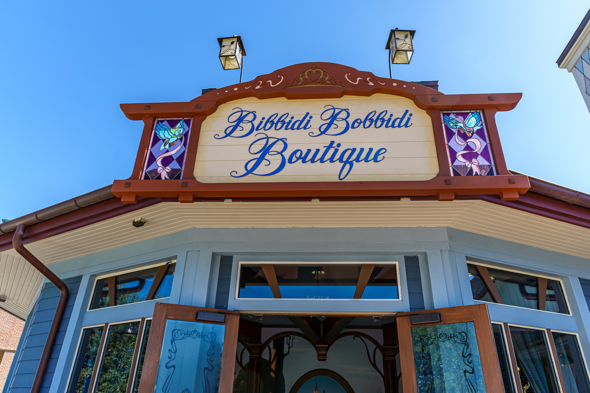 Fachada da Bibbidi Bobbidi Boutique em Disney Springs, com vitrais decorados e letreiro azul