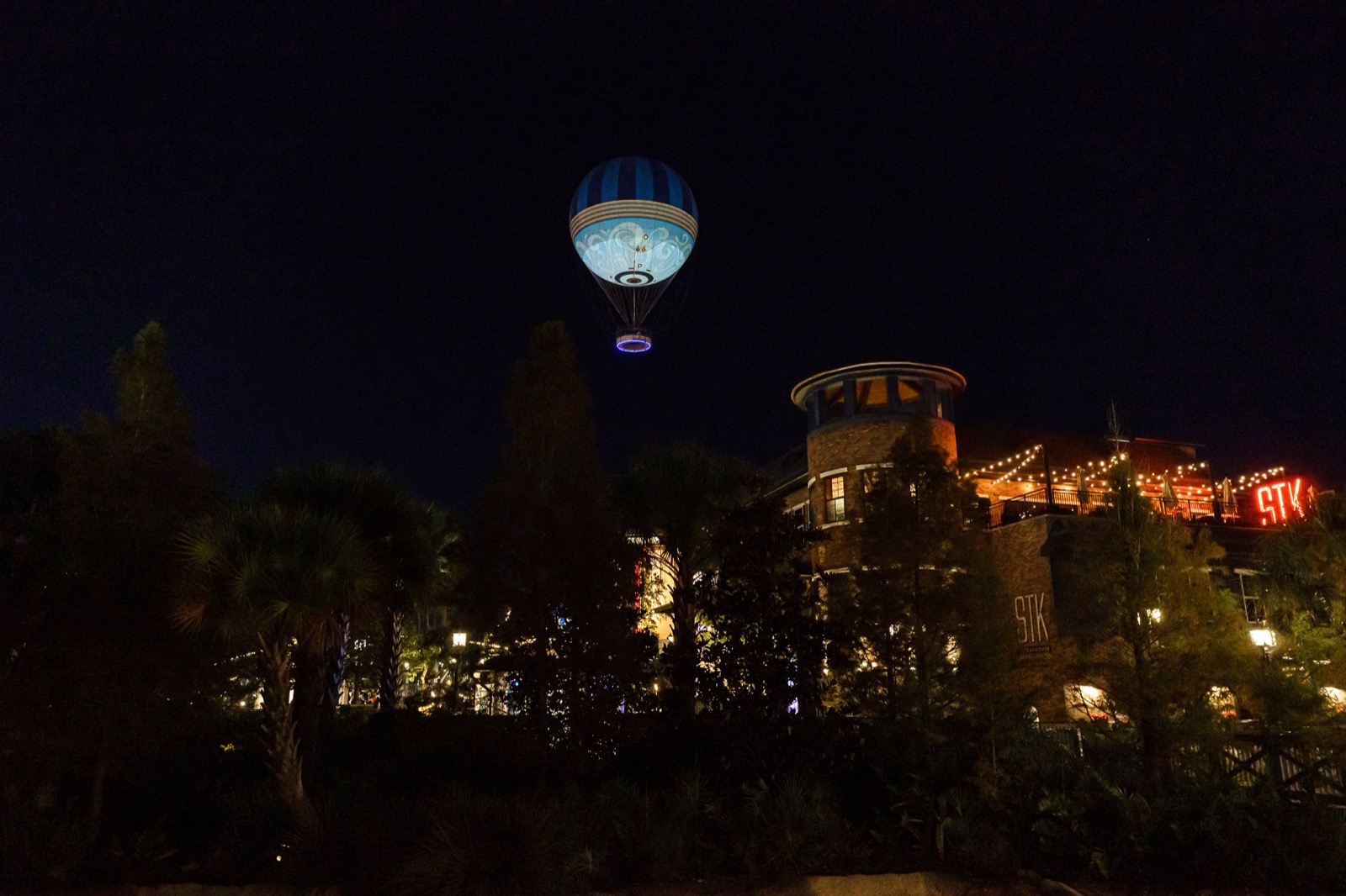 Disney Springs à noite com o balão da Aerophile iluminado