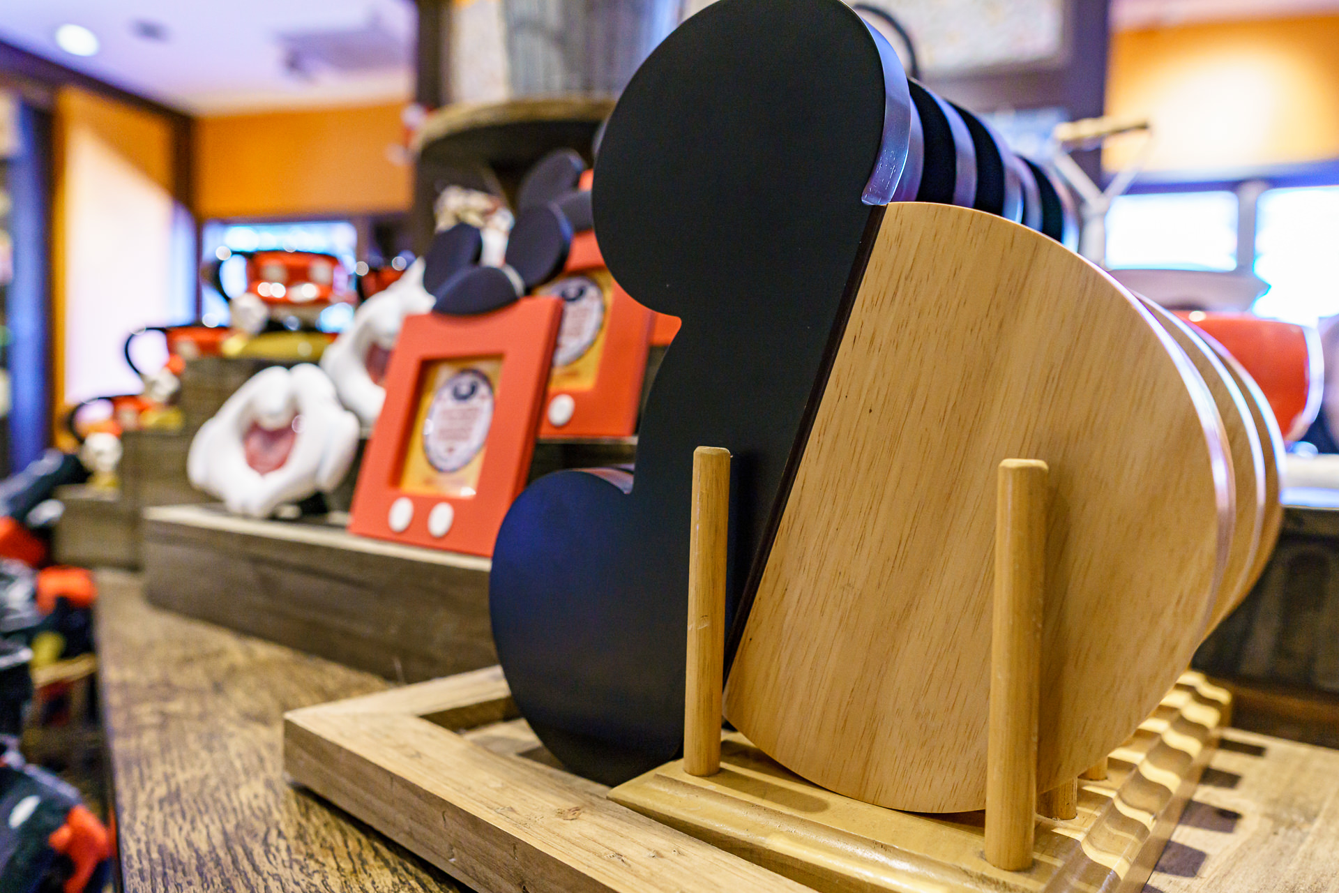Prateleiras com bonecos de pelúcia do Mickey e Minnie e porta-retratos temáticos dentro de uma loja de suvenires em Disney Springs