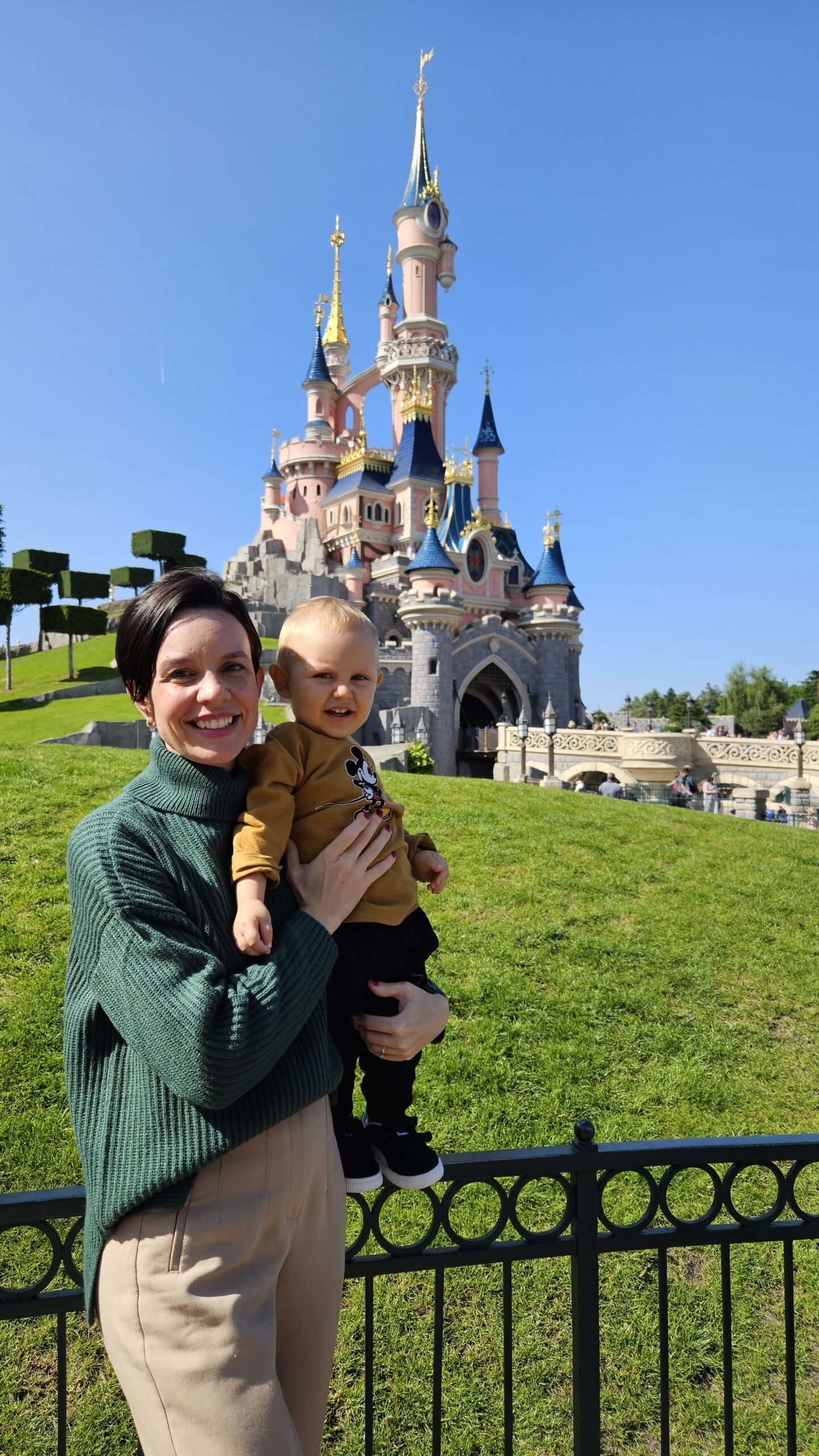 Mãe com o bebê em frente ao castelo da Disneyland Paris