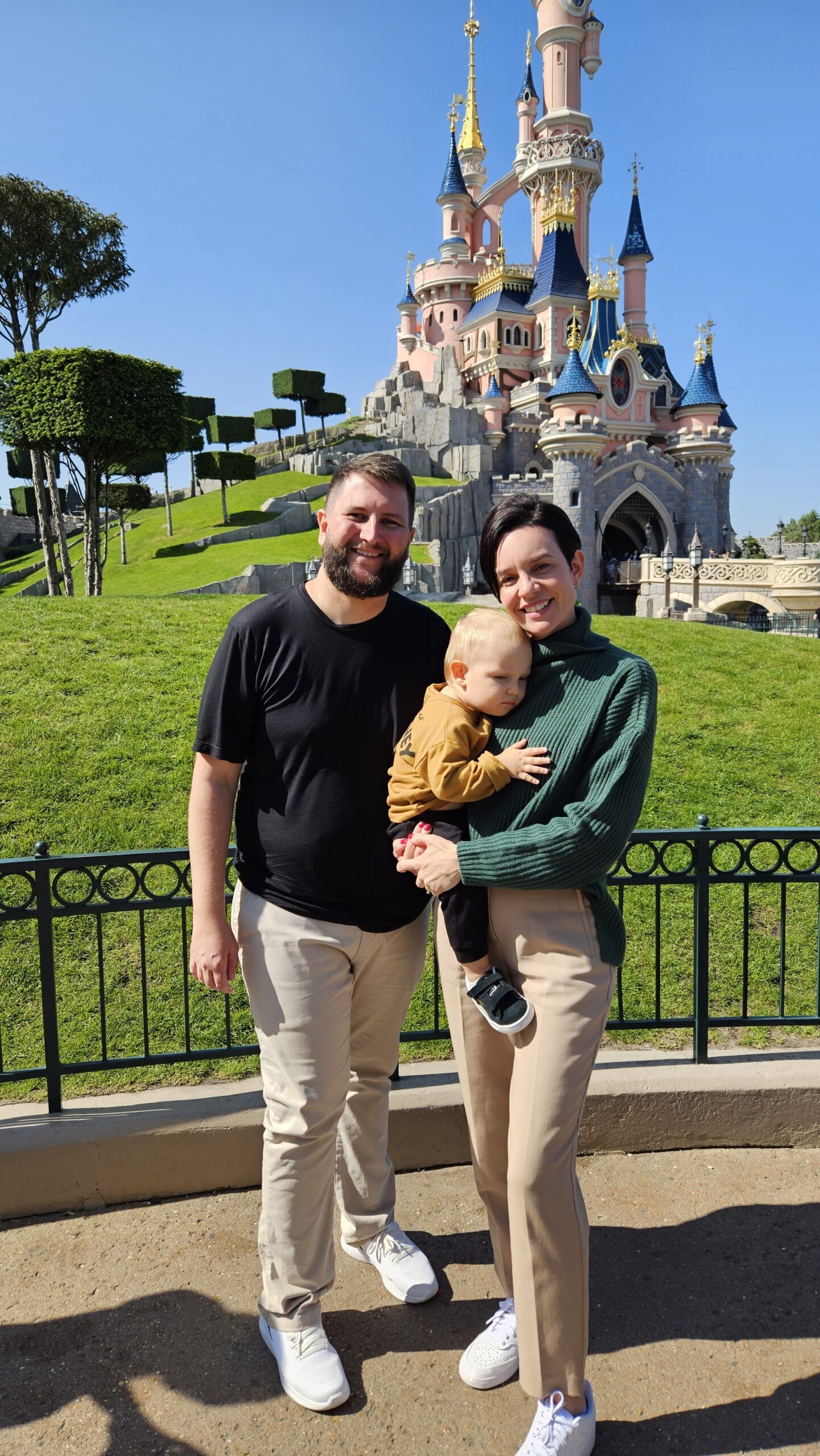 Pai com o bebê no colo em frente ao castelo da Disneyland Paris