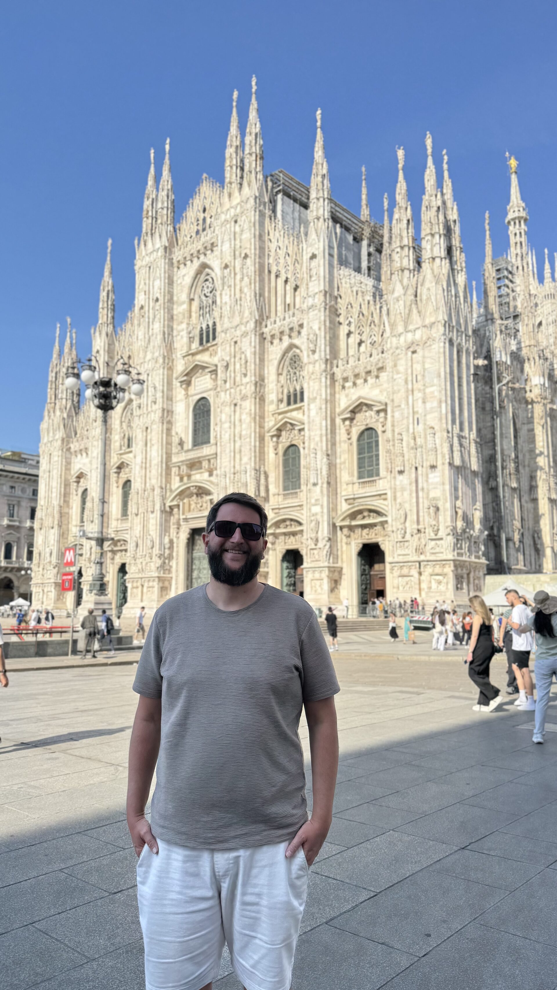 Fachada do Duomo di Milano em mármore claro, fotografada de um ângulo próximo à entrada