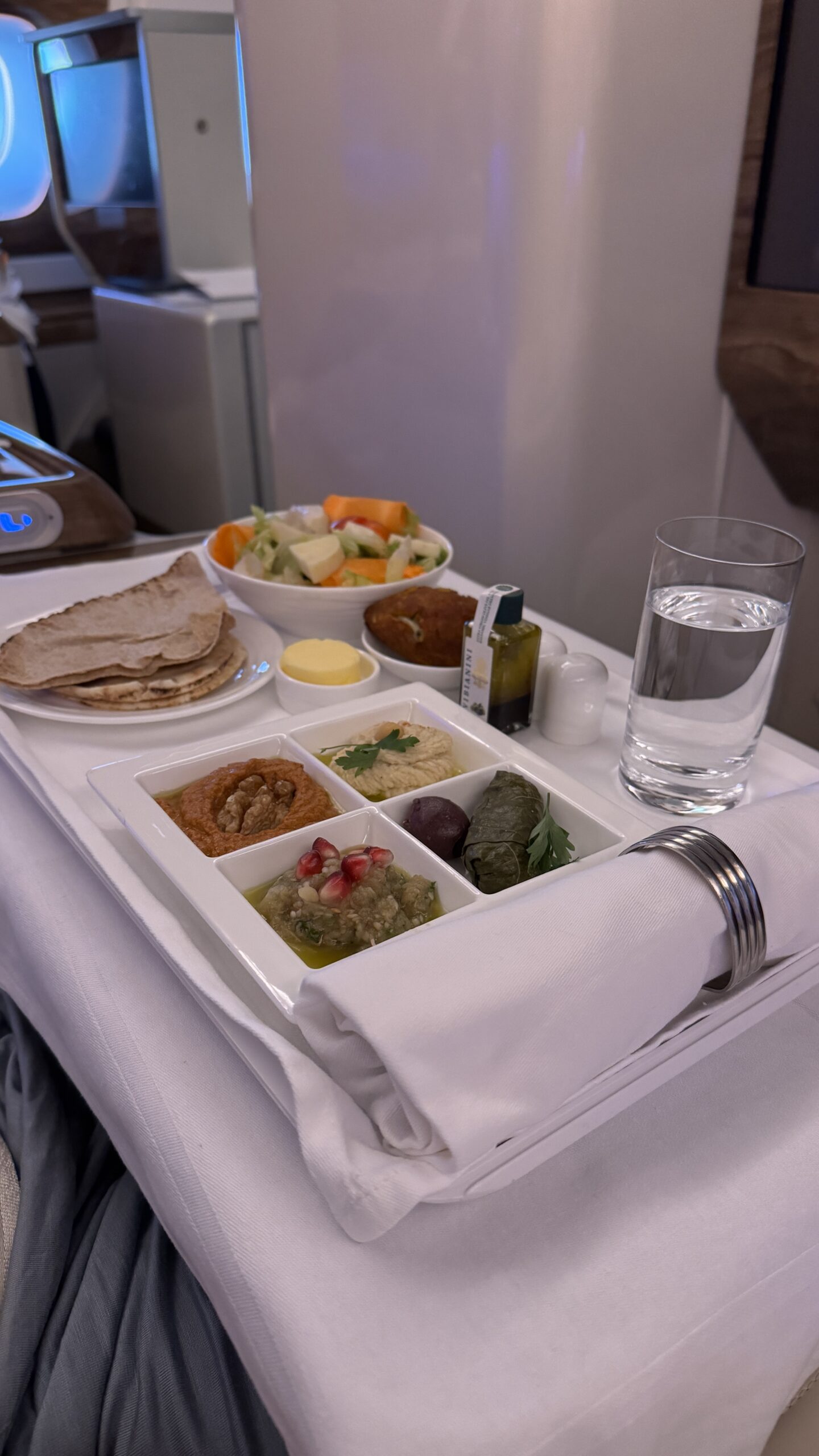 Bandeja de entradas do jantar na executiva do A380 da Emirates com mezze árabe, pães e salada