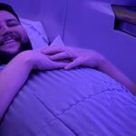 Rudi deitado na cama plana da executiva do A380 da Emirates